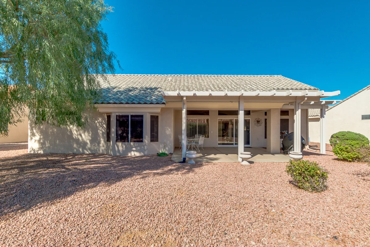 A tranquil front porch with a landscaped area and large windows, offering a peaceful spot for morning coffee or evening star-gazing. The design highlights the home’s connection to the outdoors and the inviting atmosphere of the community.