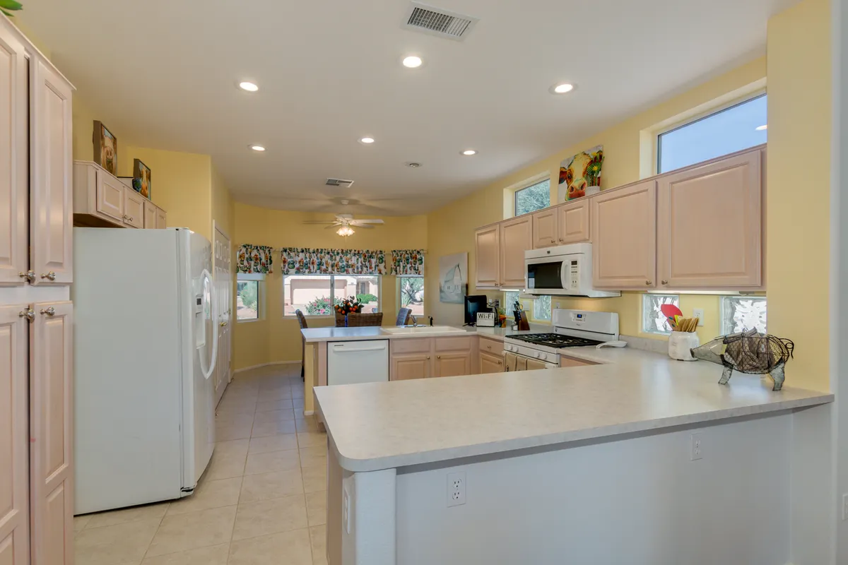 A cheerful, contemporary kitchen with a prominent island, modern appliances, and ample natural light from large windows. The space is perfectly set up for cooking, baking, and hosting festive gatherings, emphasizing both style and functionality.